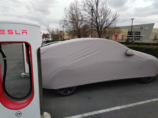 Tesla Model Y covered at supercharger.